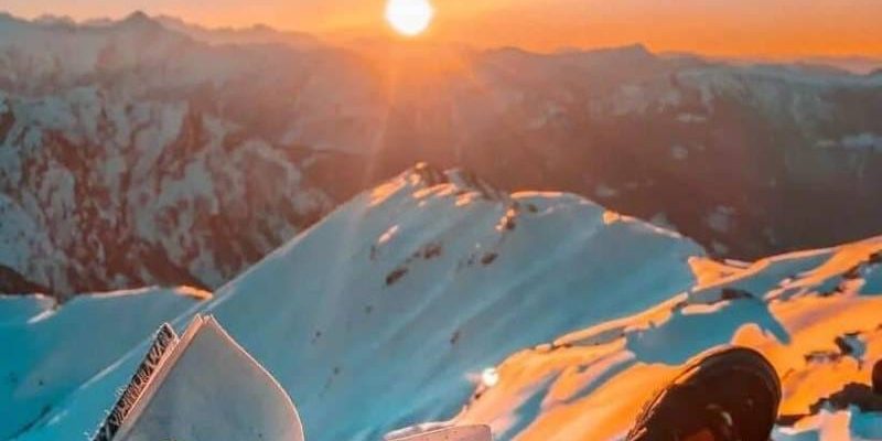 a person sitting on a mountain with a book on the top of a mountain